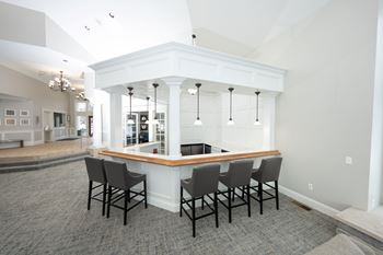 A white and wood bar with four chairs in front of it